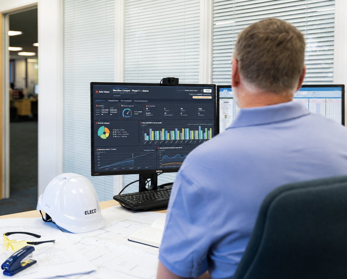 A construction planner reviewing a project programme dashboard on a computer screen